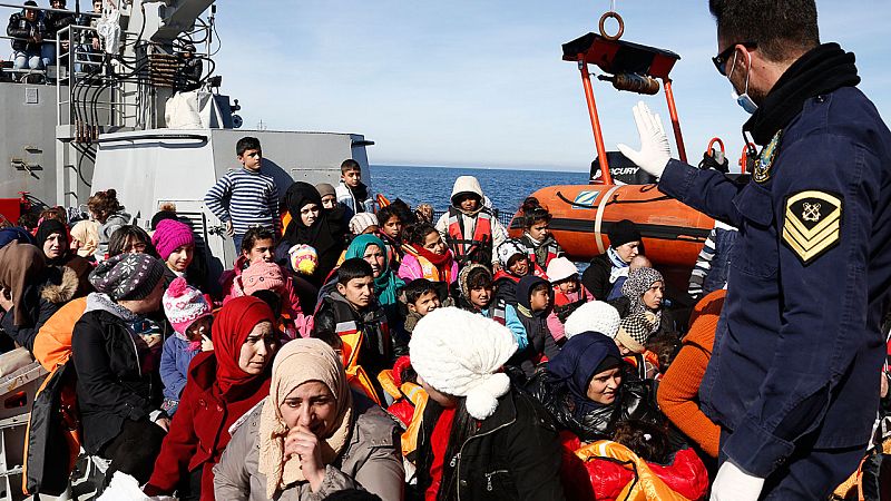 Un guardacostas griego habla a los refugiados y migrantes que acaban de ser rescatados en el Egeo.