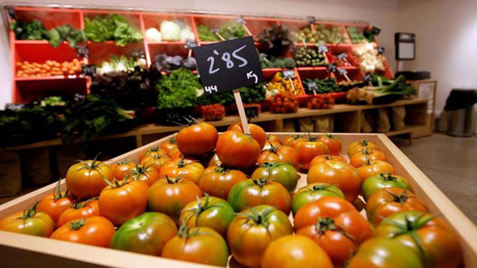 Primer plano de una caja de tomates en una frutería