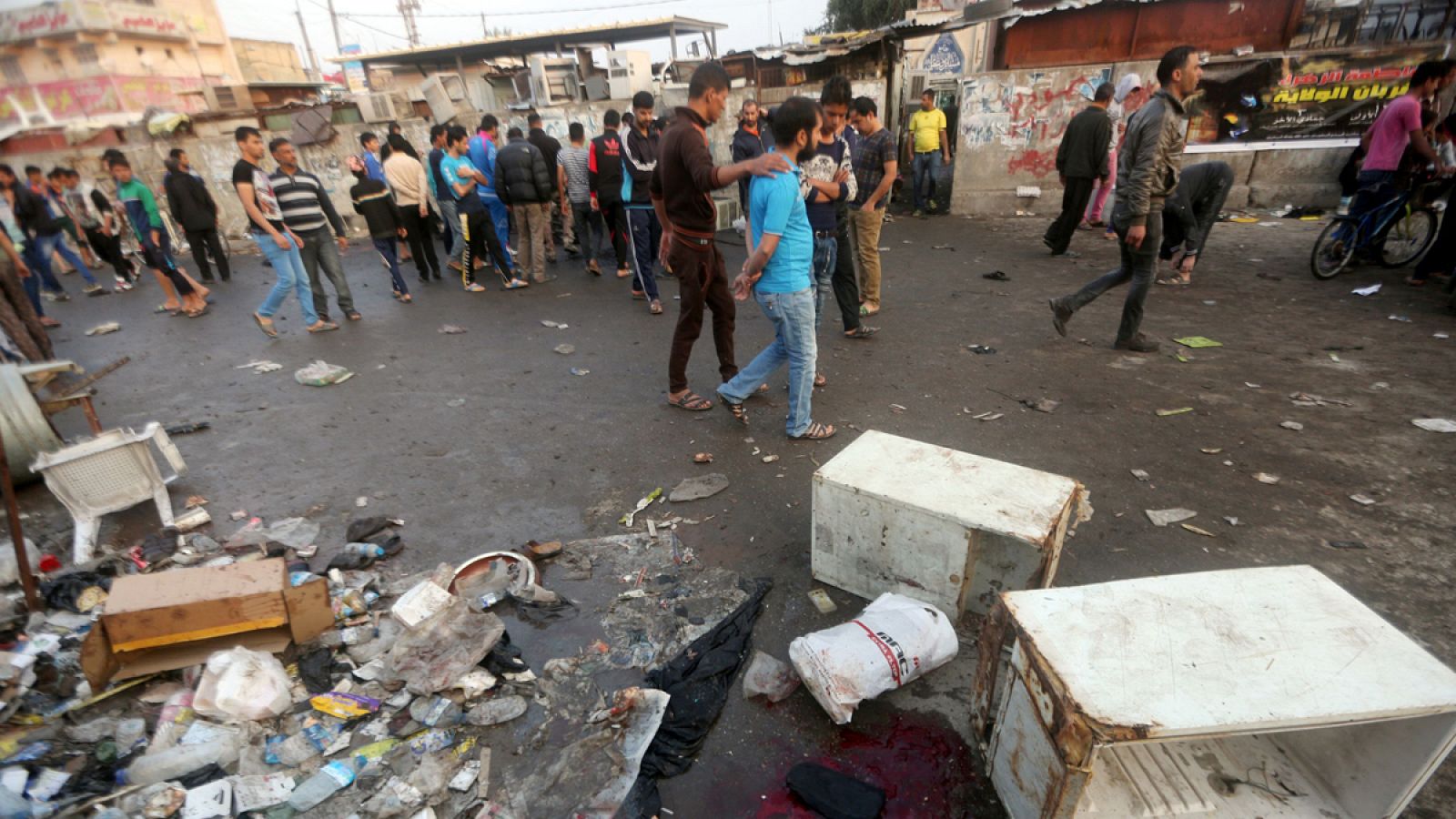 Los ciudadanos supervisan el daño en el lugar donde se ha producido la explosión, cerca de un mercado al norte de Bagdad