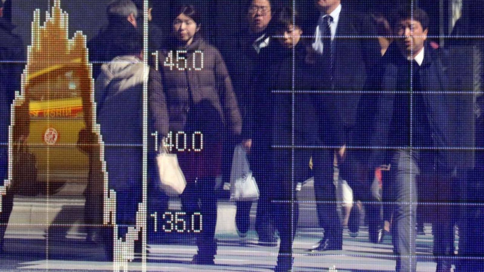 Peatones, reflejados en una pantalla electrónica con los datos de mercados financieros en una calle de Tokio