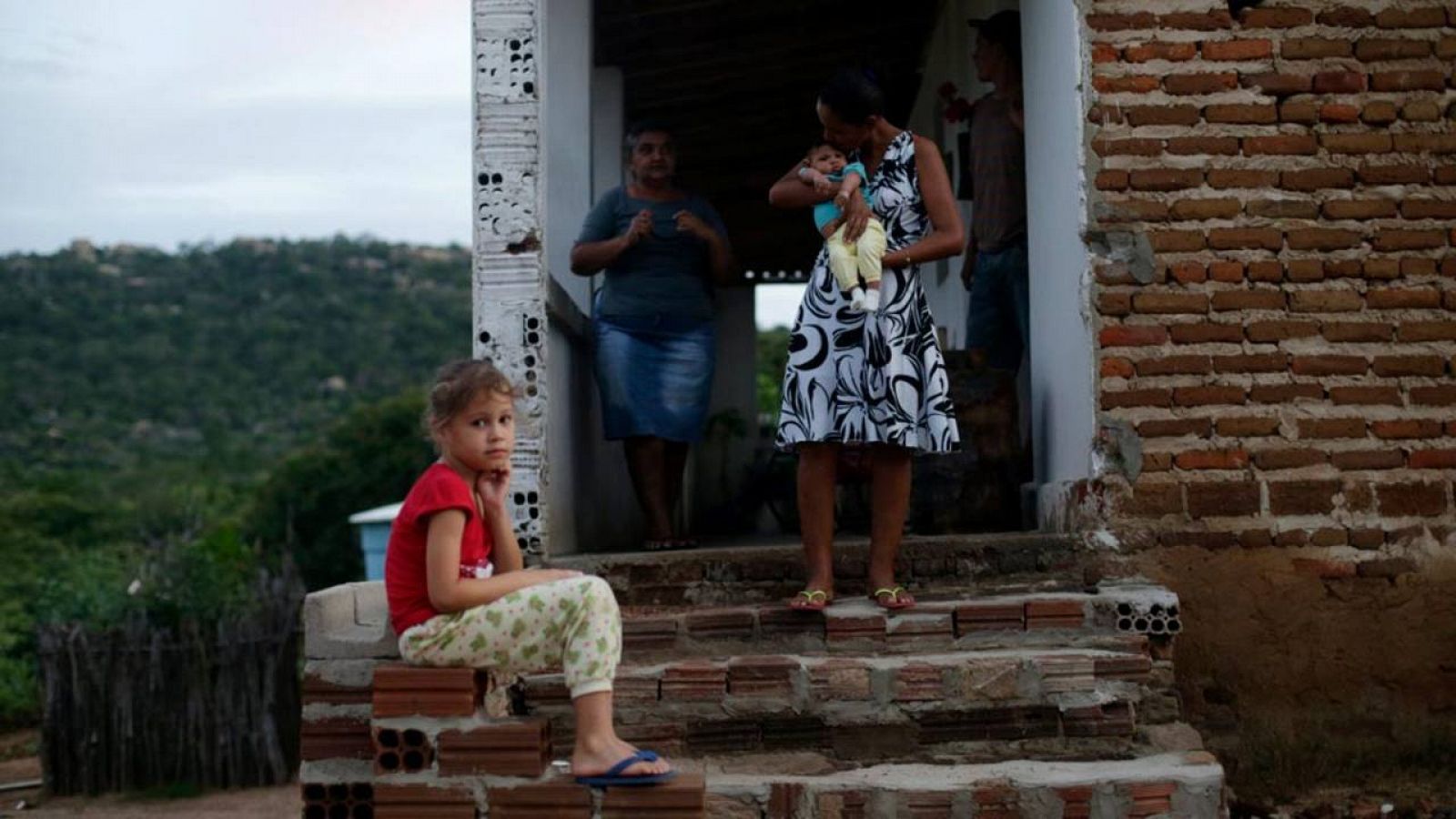 Una madre sostiene a un bebe con microcefalia en Brasil