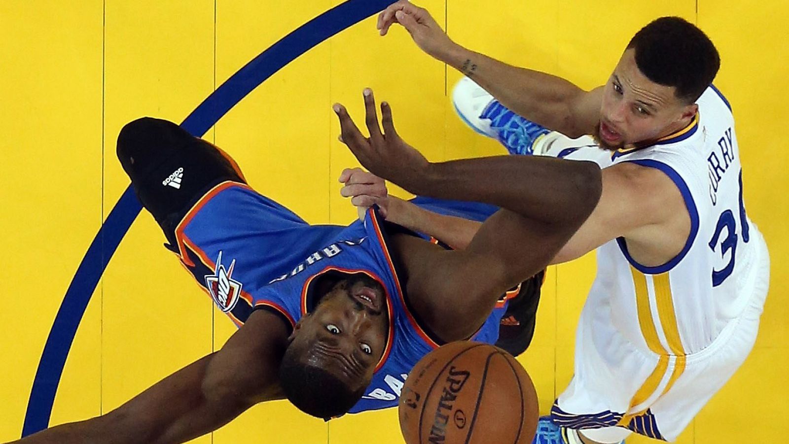 Curry (derecha) pugna un rebote con Ibaka