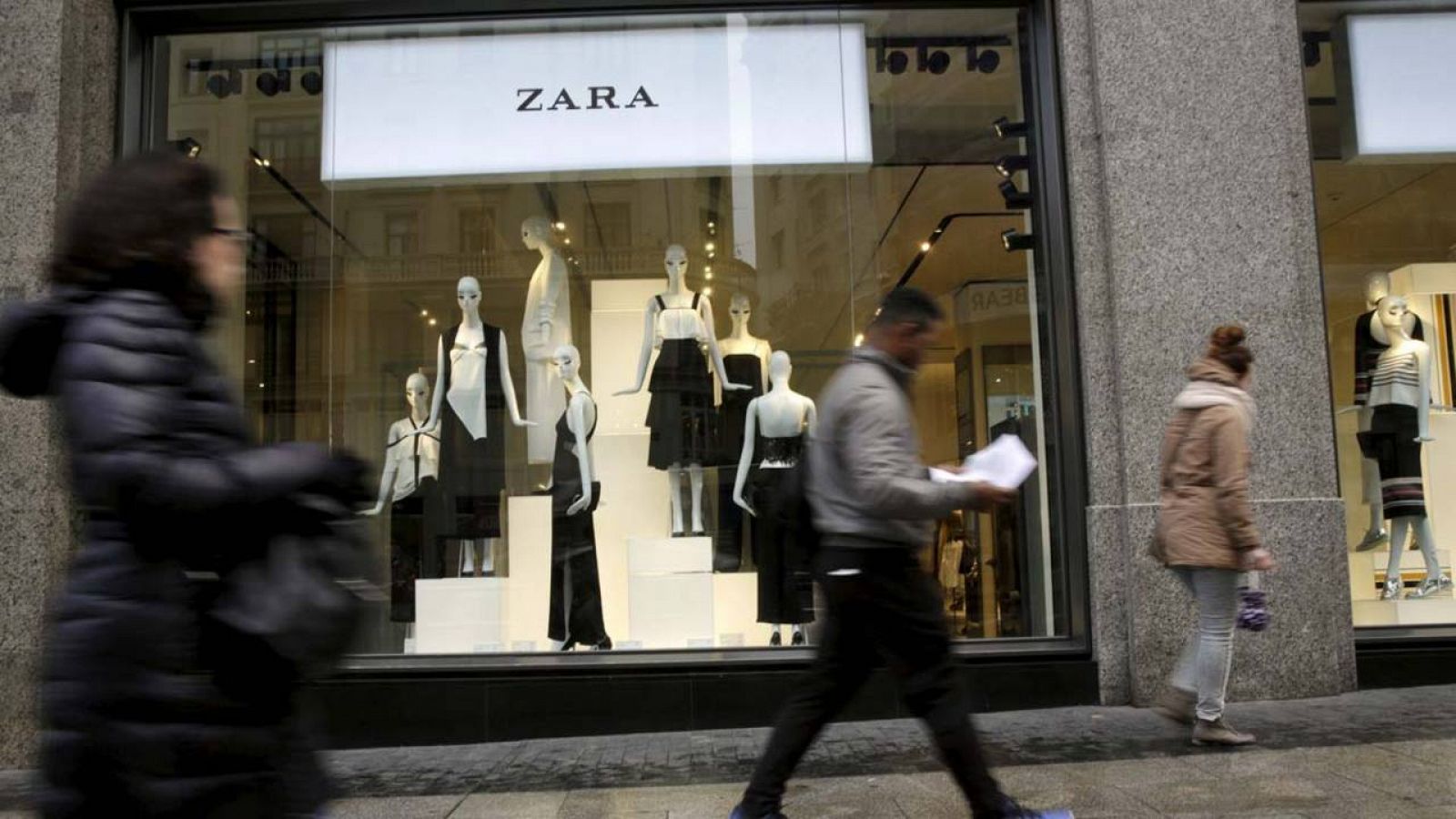 Transeúntes pasan por delante de una tienda de Zara en el centro de Madrid
