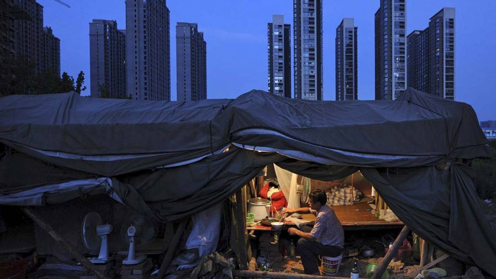 Un trabajador cocina en una infravivienda en la ciudad china de Hefei