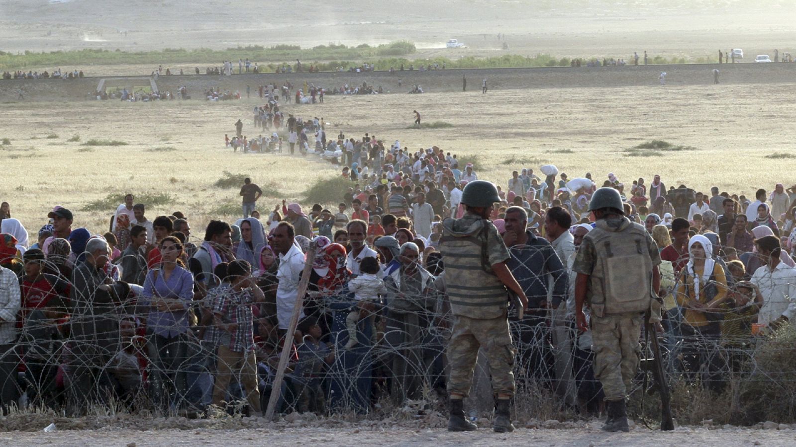 Soldados turcos vigilan a los refugiados sirios que llegan a la frontera en la localidad de Suruç