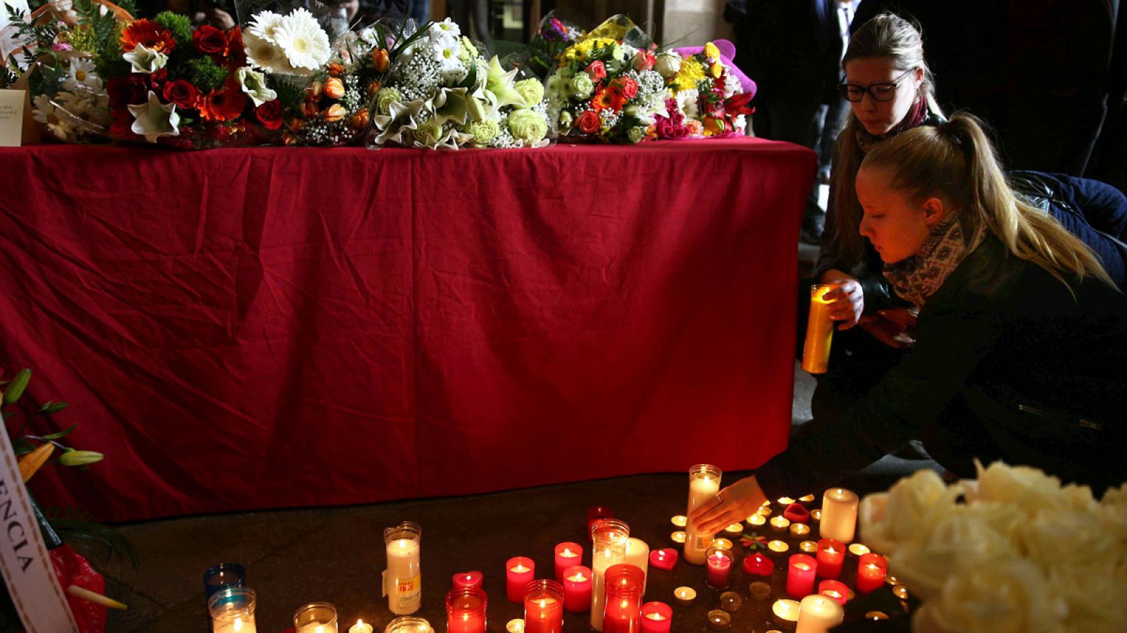 Unas jóvenes encienden velas en la Universidad de Barcelona (UB) en memoria de las víctimas del accidente de autocar de Tarragona.