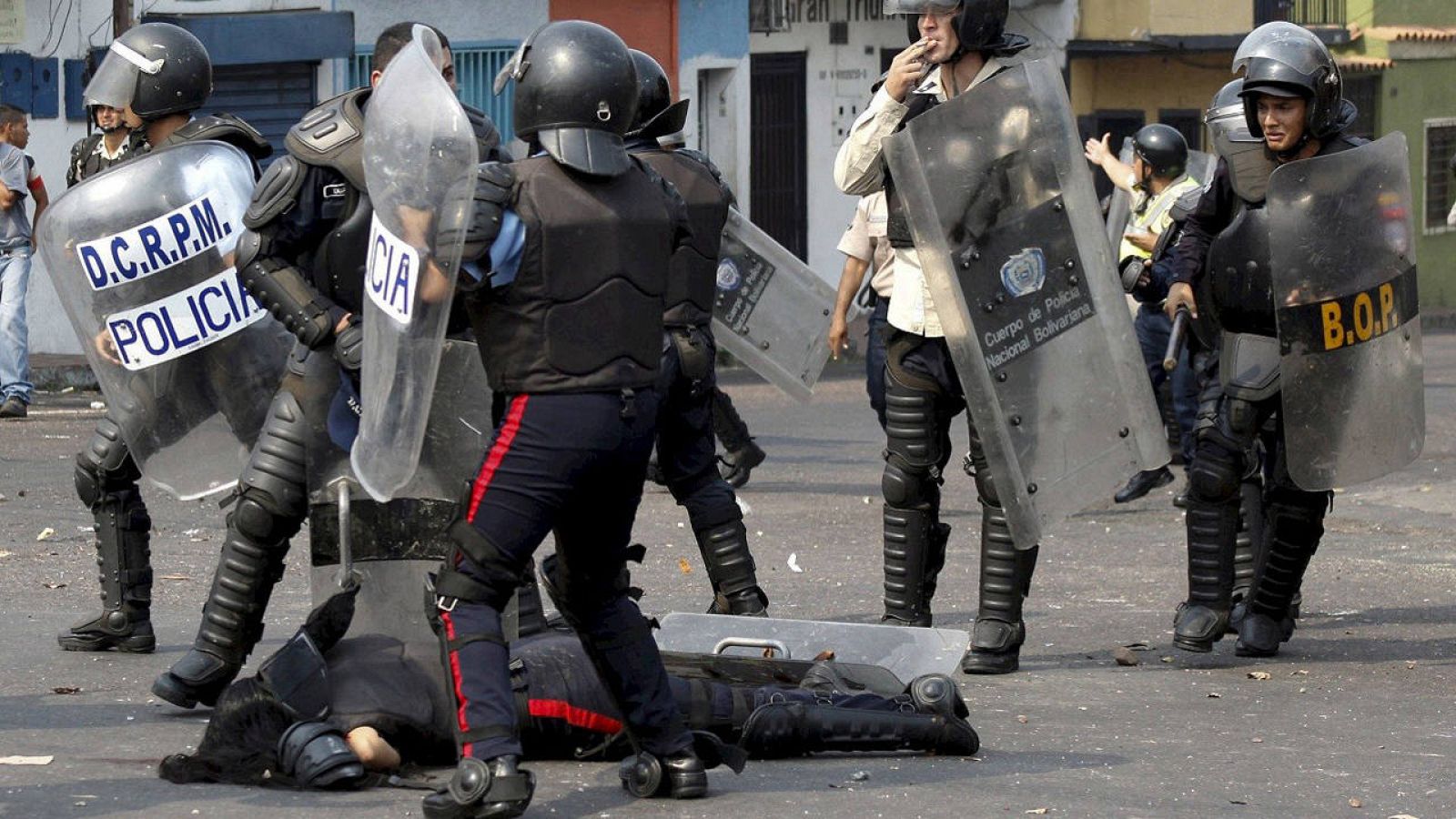 Agentes ayudan a una compañera herida tras ser arrollada por un autobús durante una protesta en la ciudad de San Cristóbal, en Venezuela, el 29 de marzo de 2016. REUTERS/Carlos Eduardo Ramírez