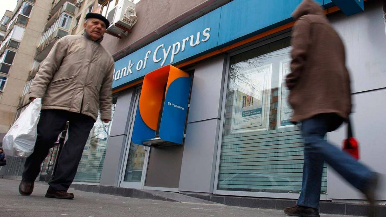 Dos transeúntes pasan por delante de una oficina del Banco de Chipre