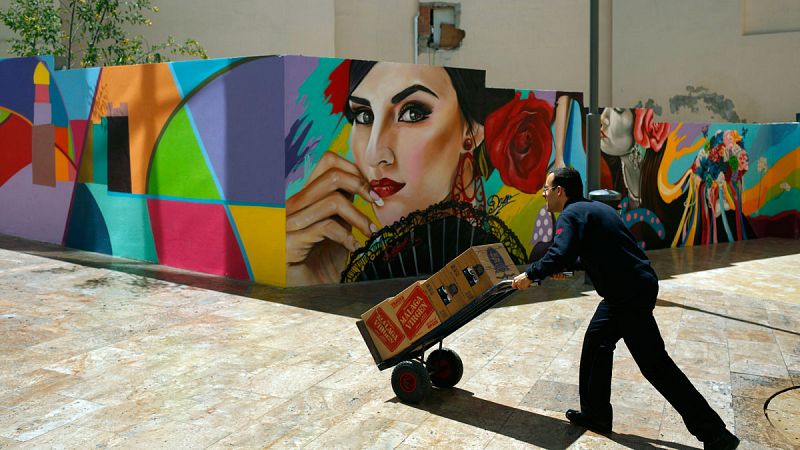 Un camarero empuja una carretilla con cajas de bebidas en Málaga