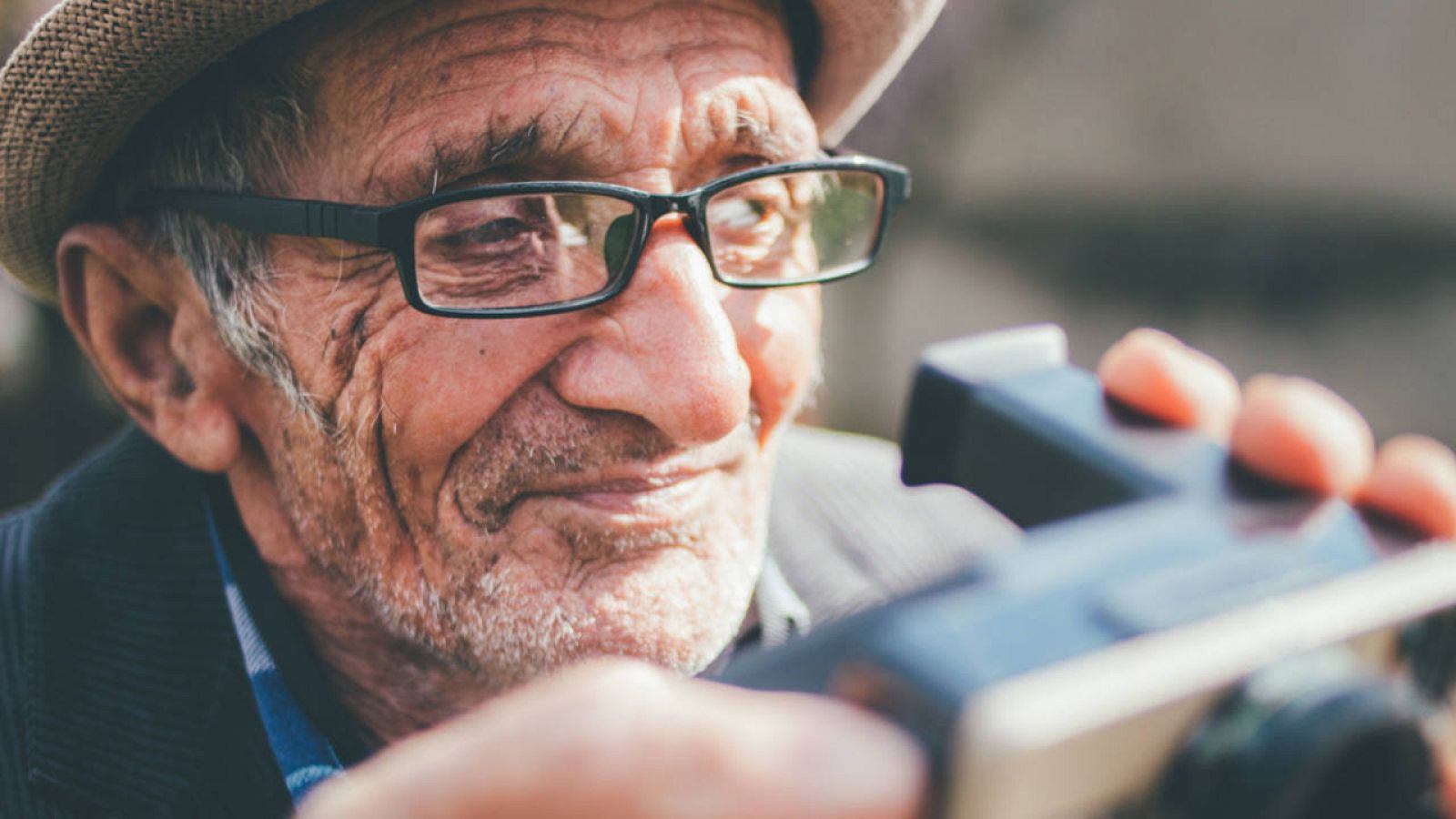  Retrato de un fogógrafo maduro sosteniendo su cámara Polaroid.