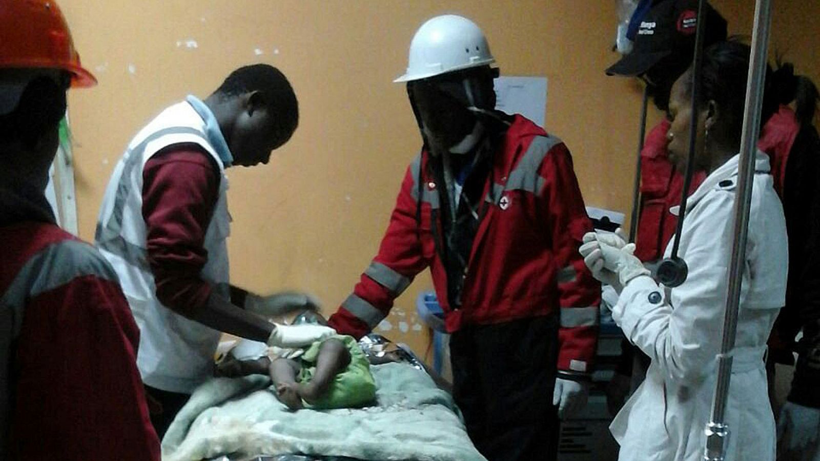 El personal de Cruz Roja keniana atiende al bebé rescatado tras pasar 80 horas entre los escombros del derrumbe en Kenia.