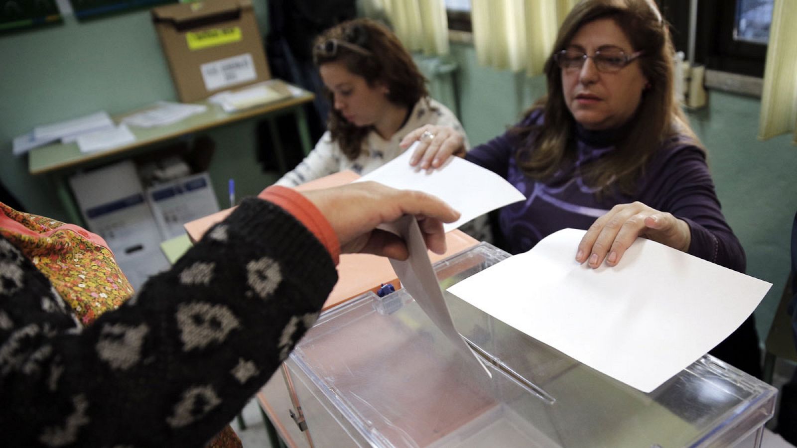 Una mujer deposita su voto en el colegio electoral República de Eduador en Madrid en las elecciones generales del 20 de diciembre