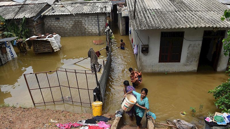 Residentes del suburbio de Kelaniya, en Colombo, Sri Lanka, intentan salvar sus enseres de la inundación, el 18 de mayo de 2016. AFP PHOTO / ISHARA S.KODIKARA