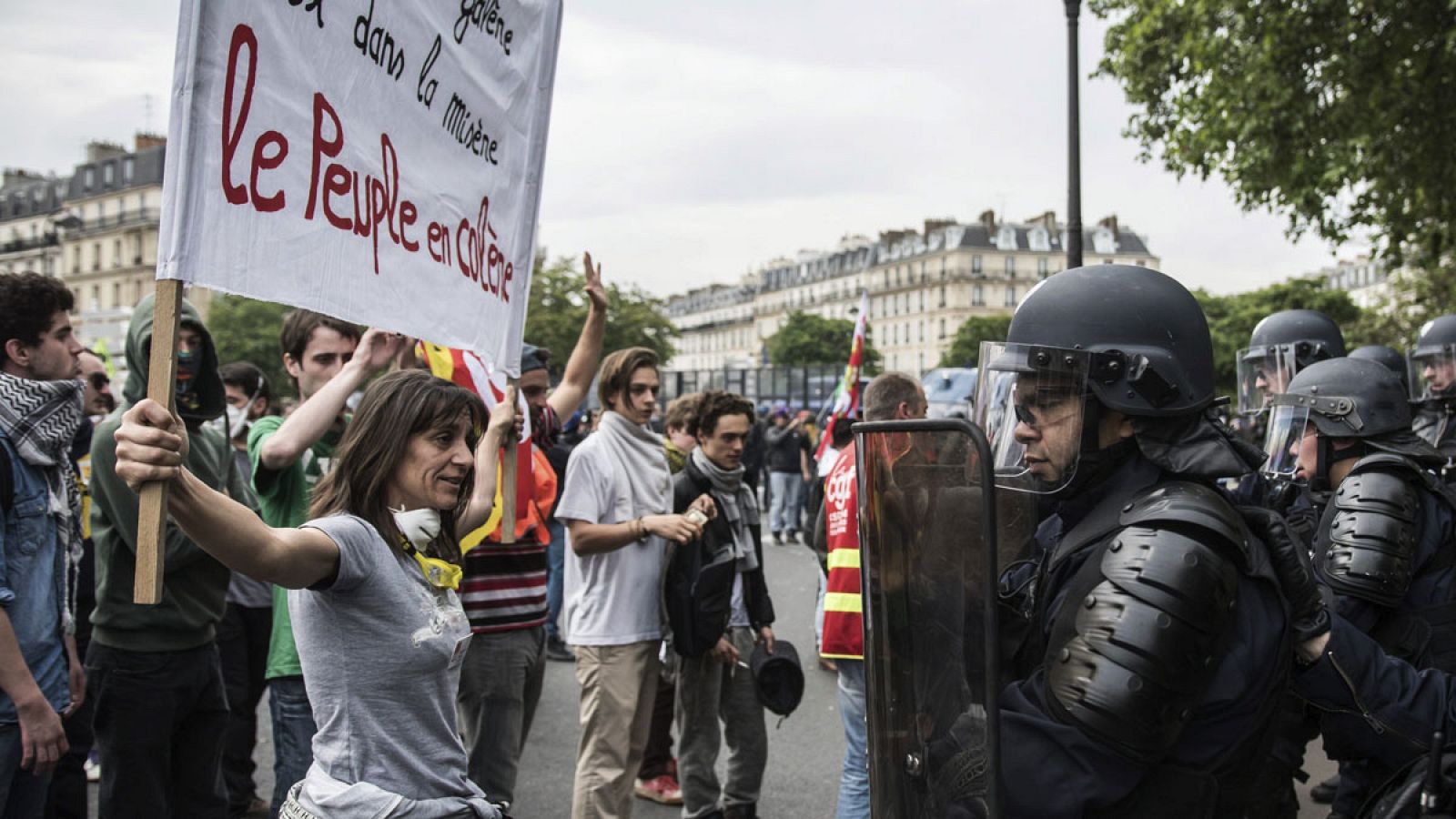 Una manifestante enarbola una pancarta sobre la ira de los franceses