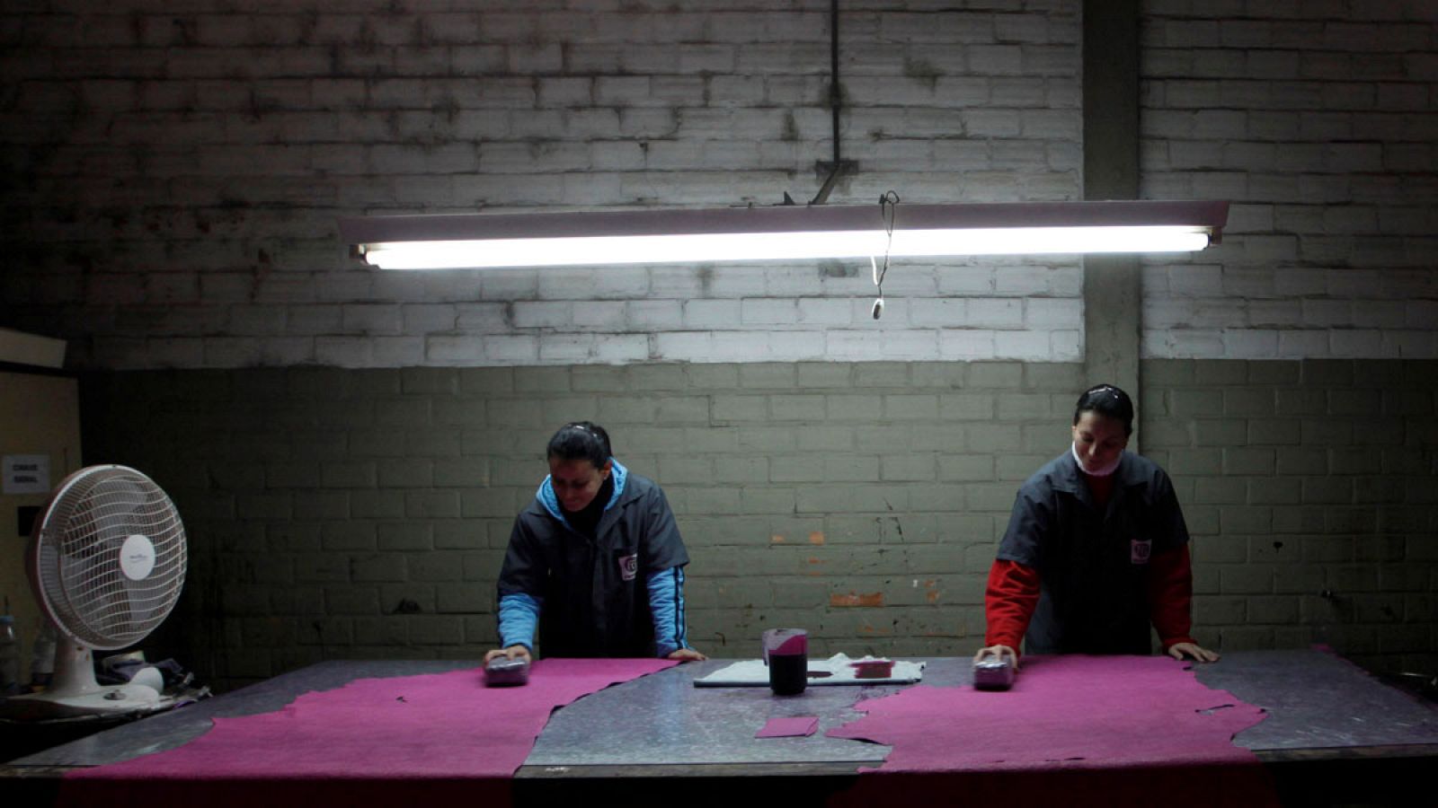 Dos trabajadores brasileños dan un color a un trozo de cuero en una imagen de archivo