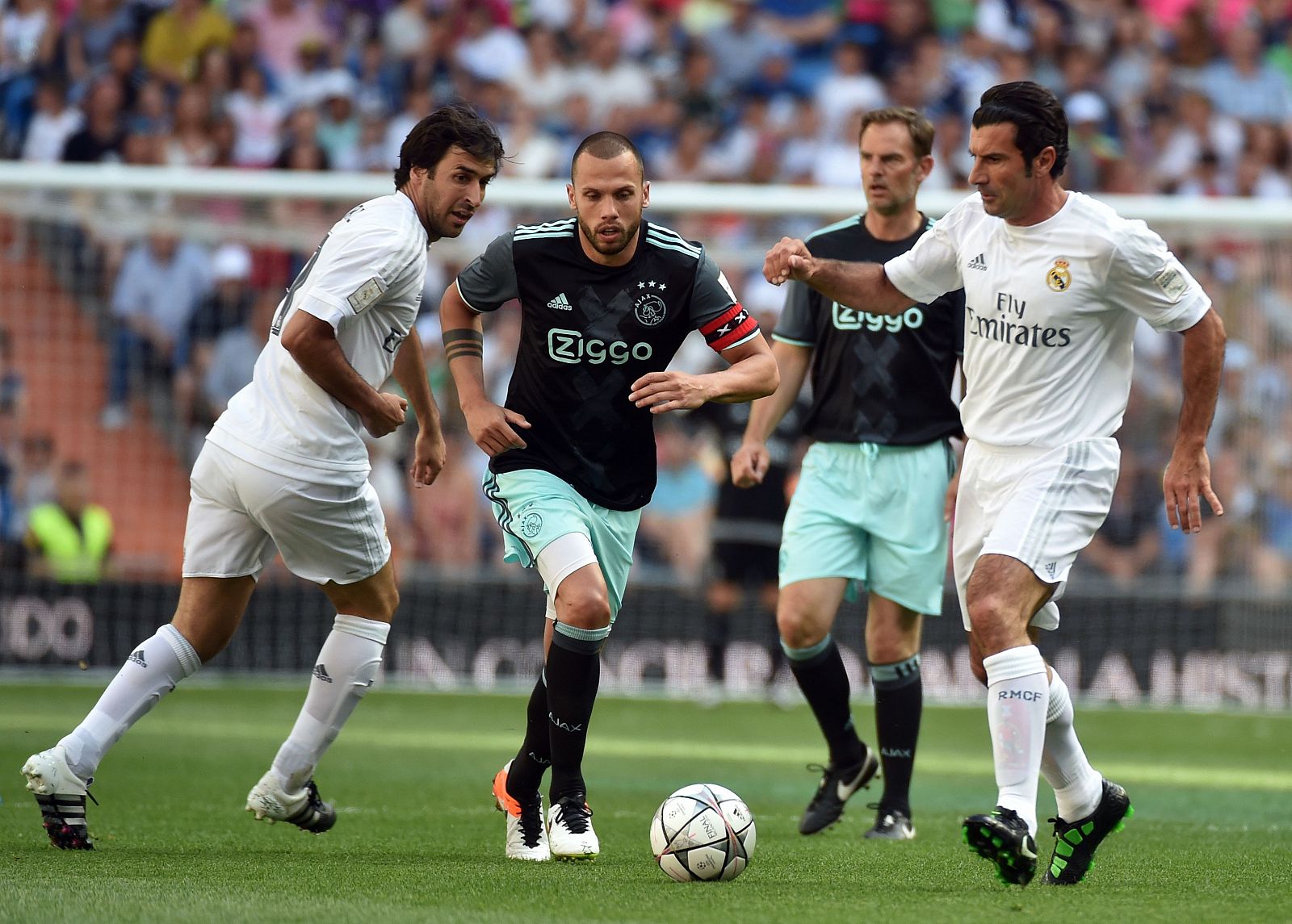 Heitinga, entre Raúl (izquierda) y Figo durante el partido de veteranos entre el Real Madrid y el Ajax.