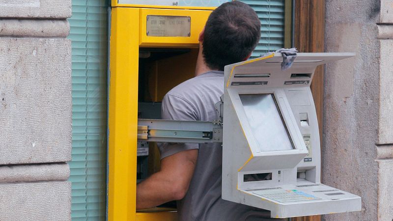 Un técnico arregla un cajero automático