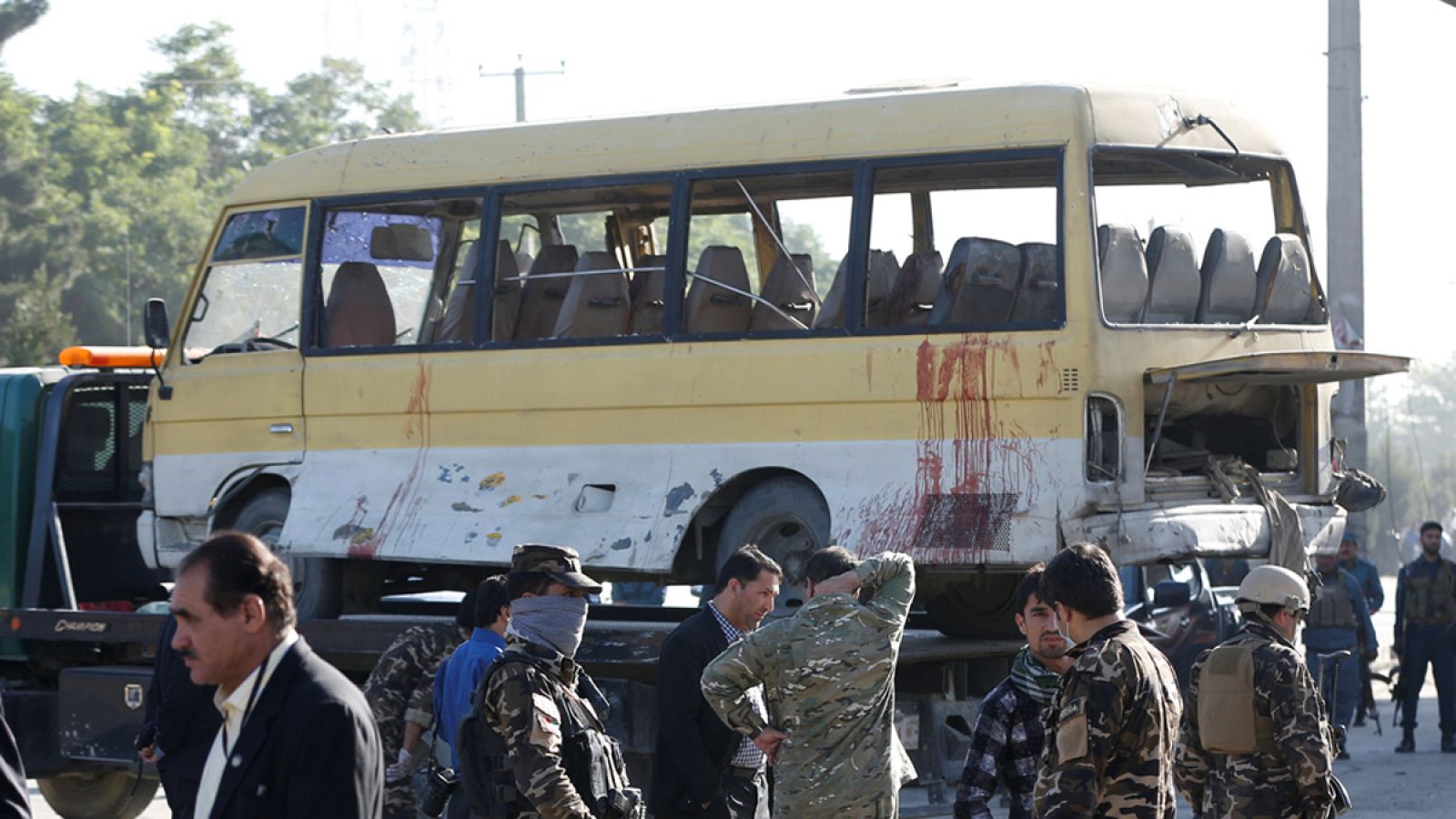 Las fuerzas de seguridad afganas inspeccionan el autobús contra el que atentó un atacante suicida en Kabul.