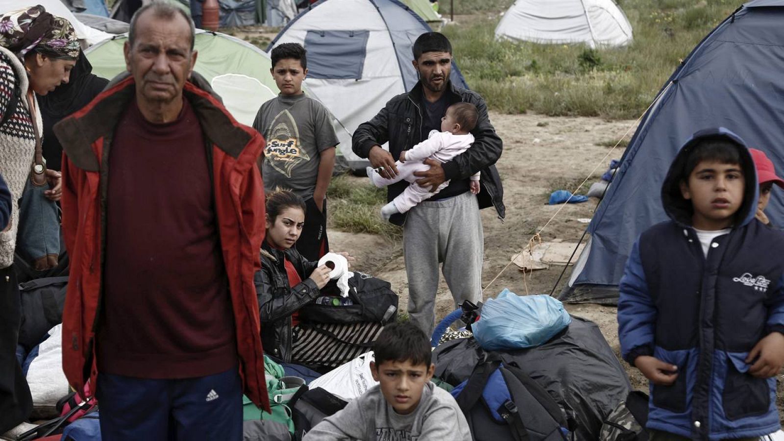 Familias de refugiados esperan para ser llevados a otros centros de acogida durante el desalojo del campamento de refugiados de Idomeni