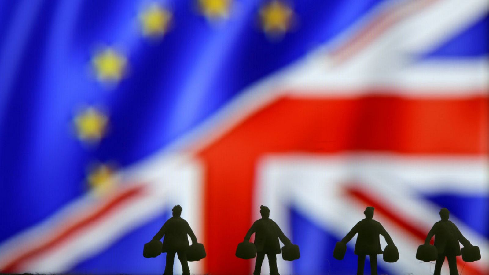 Figuras con maletines ante las banderas de la UE y el Reino Unido