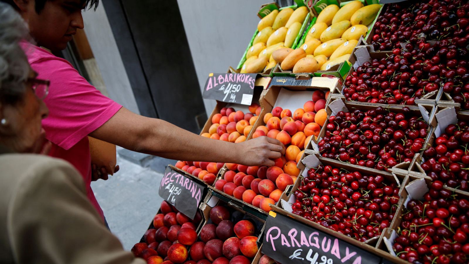 Una anciana compra fruta en Madrid