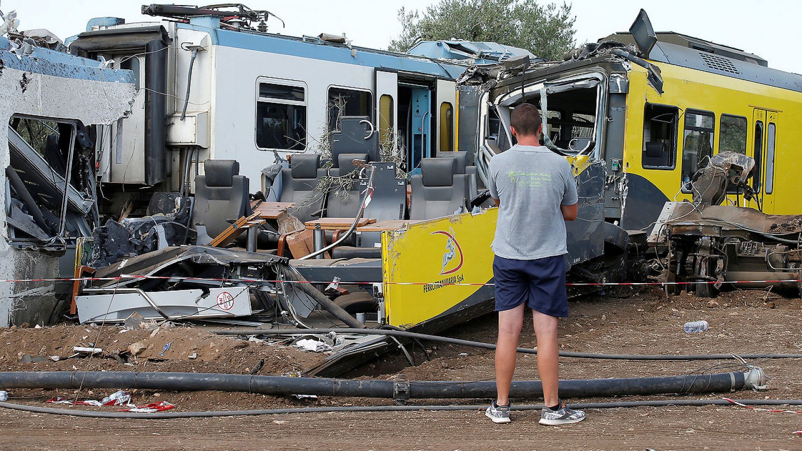 Un hombre mira, el 13 de julio de 2016, los restos de los trenes que chocaron entre Andria y Corato, cerca de Bari, sur de Italia.  REUTERS/Alessandro Garofalo