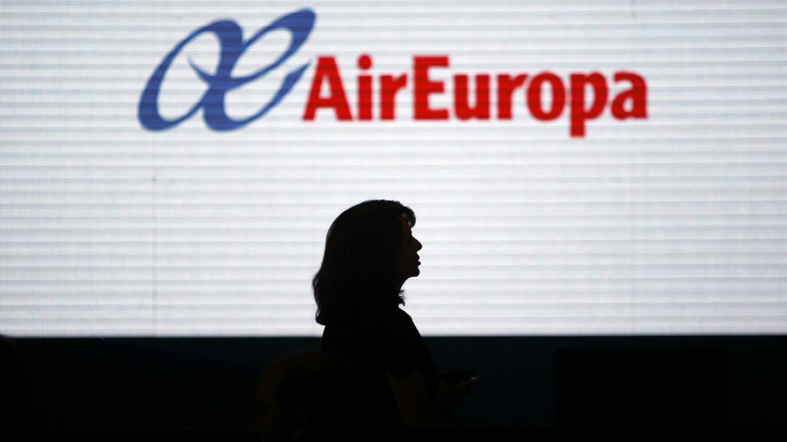 La silueta de una mujer se dibuja sobre una pantalla con el logotipo de Air Europa