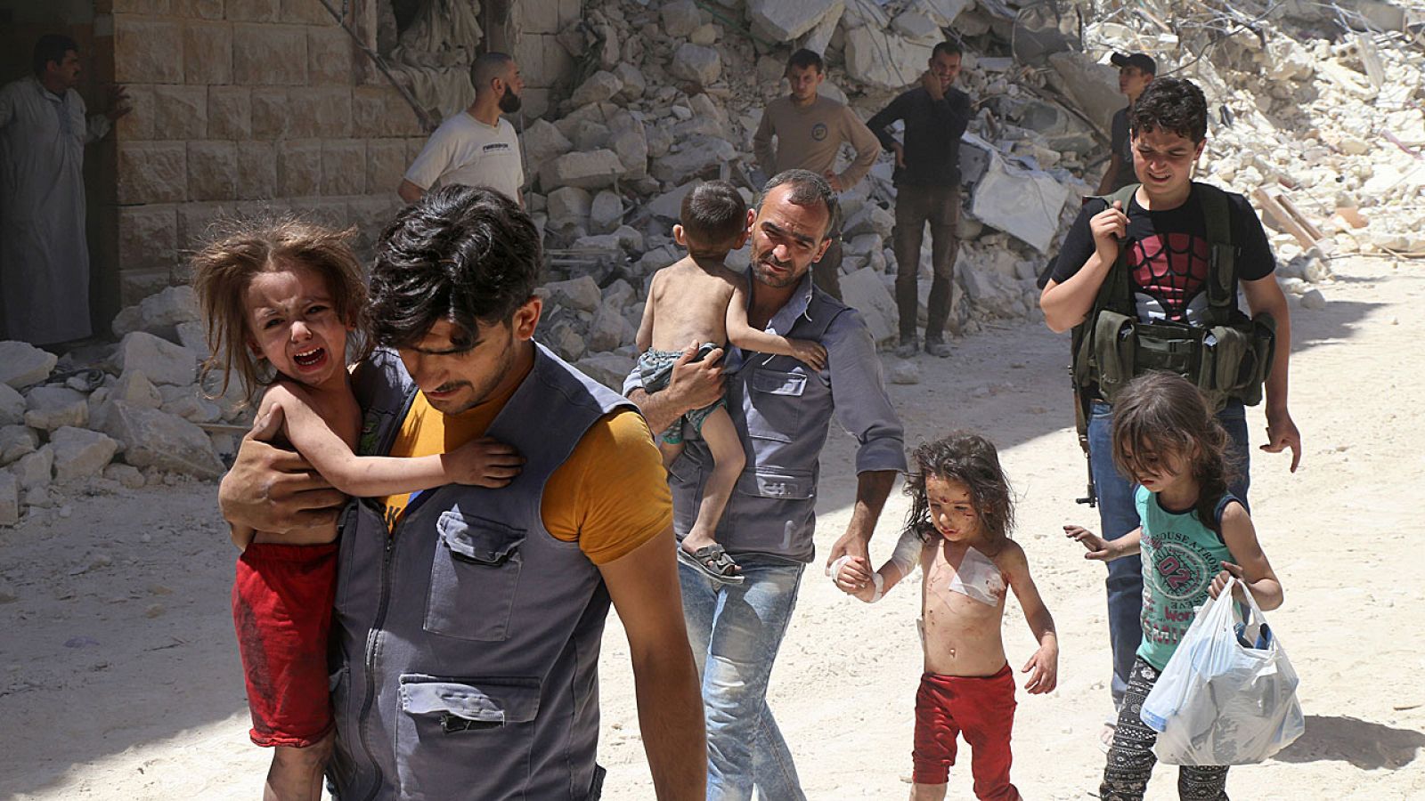 Hombres sirios trasladan a un hospital a niños heridos en un bombardeo en el norte de Alepo este lunes.