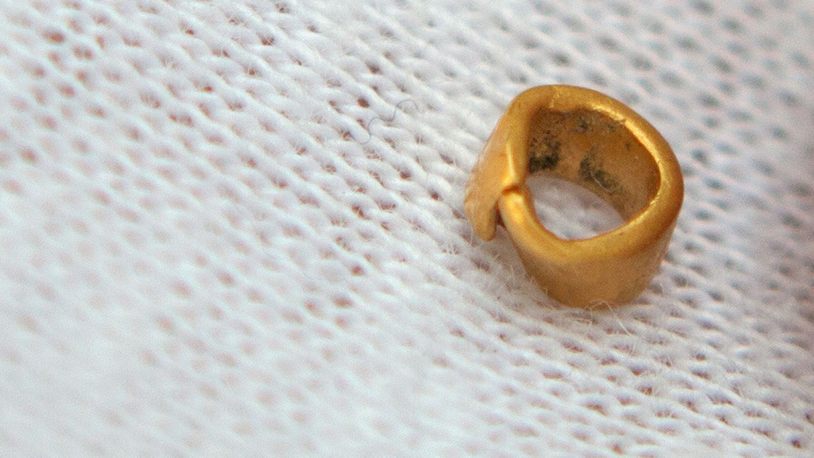 El objeto de oro hallado parece un abalorio.