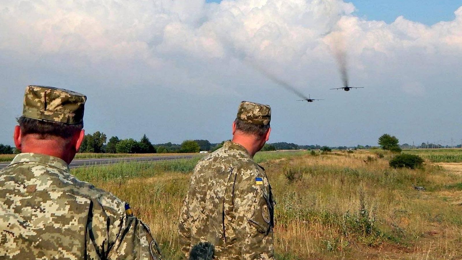Dos soldados ucranianos observan el vuelo de dos bombarderos Sujoi Su-24 en el este de Ucrania