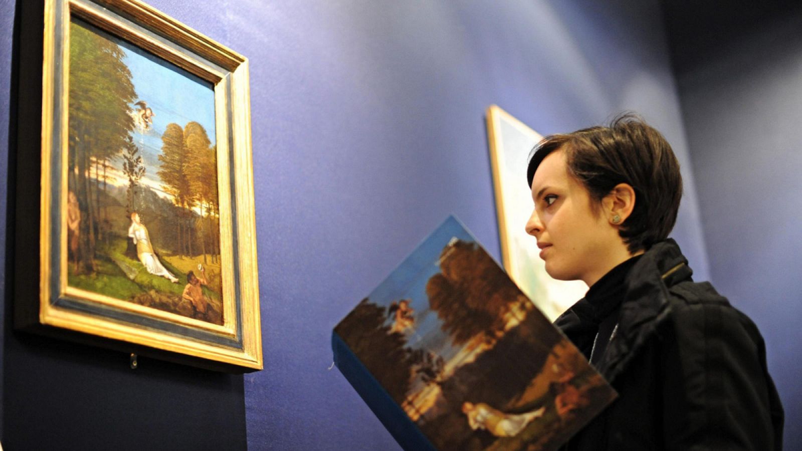 Una joven contempla la pintura 'Alegoría de la Castidad', del pintor italiano Lorenzo Lotto, en la Galería Palatina del Palacio Pitti, Florencia