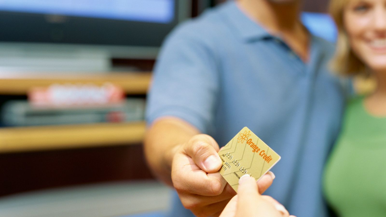 Una pareja paga su compra en una tienda con una tarjeta de crédito