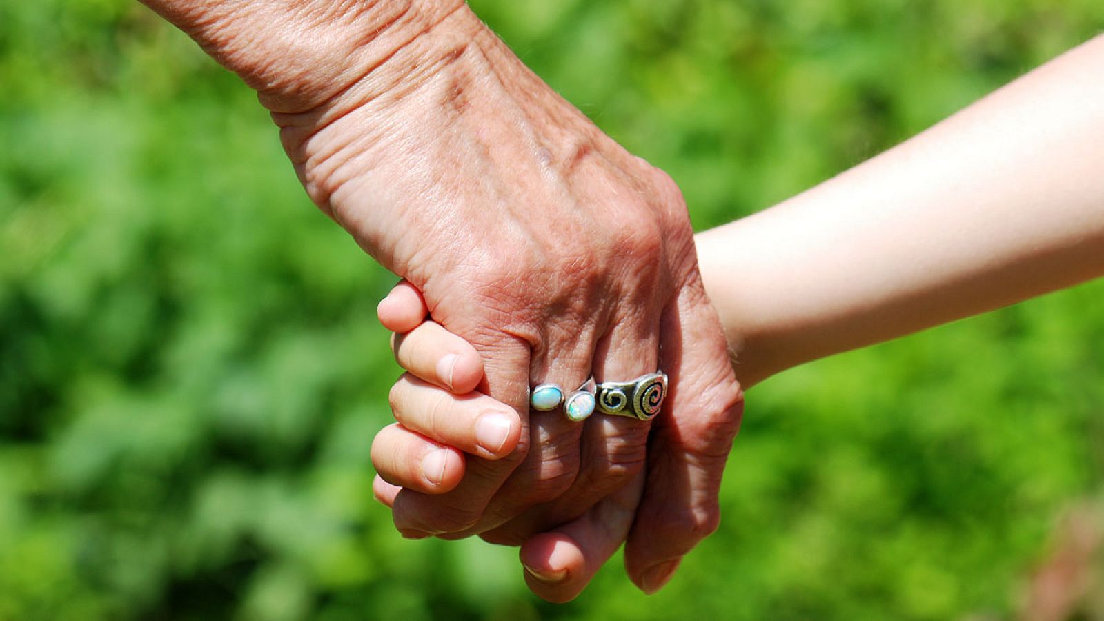 Una abuela coge de la mano a su nieto