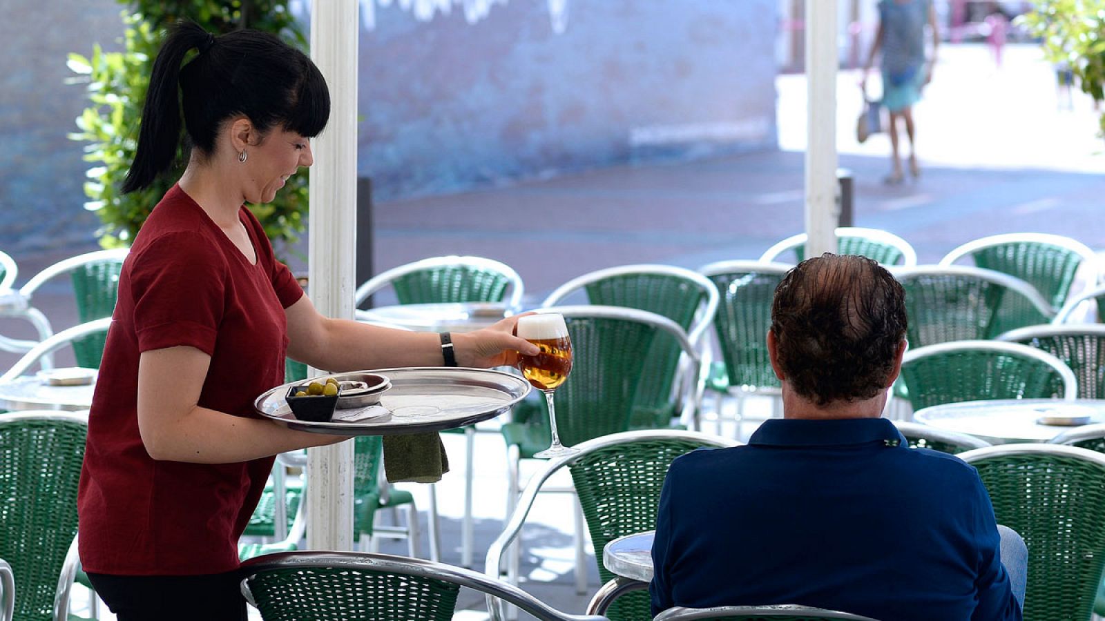 Una camarera sirve una consumición en una terraza de Valladolid