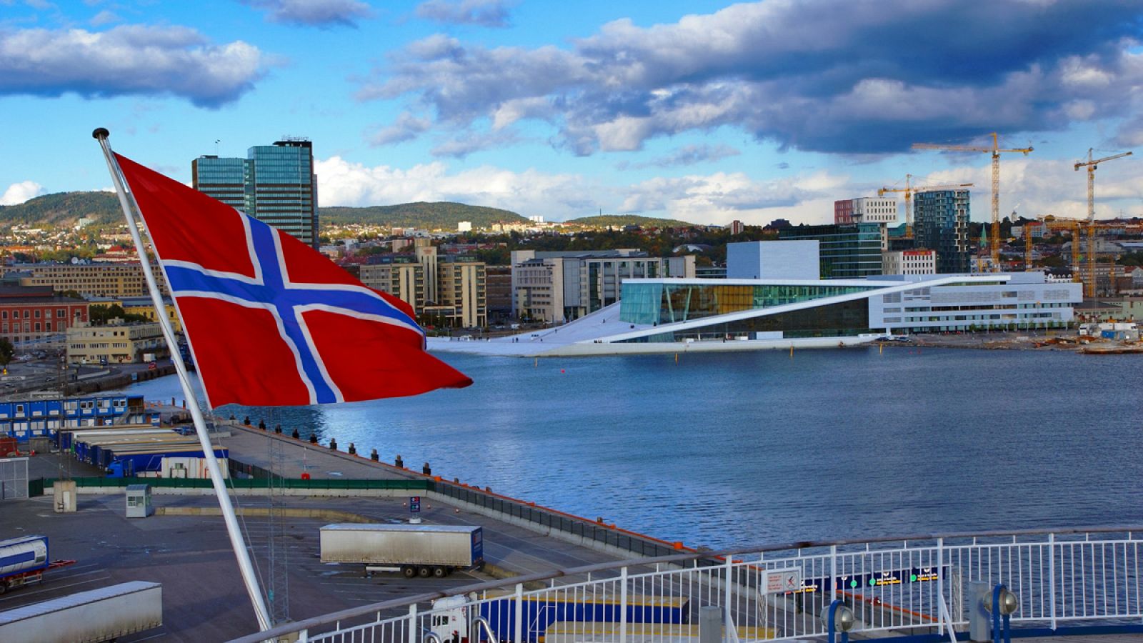 Una panorámica de Oslo con la bandera de Noruega en primer plano