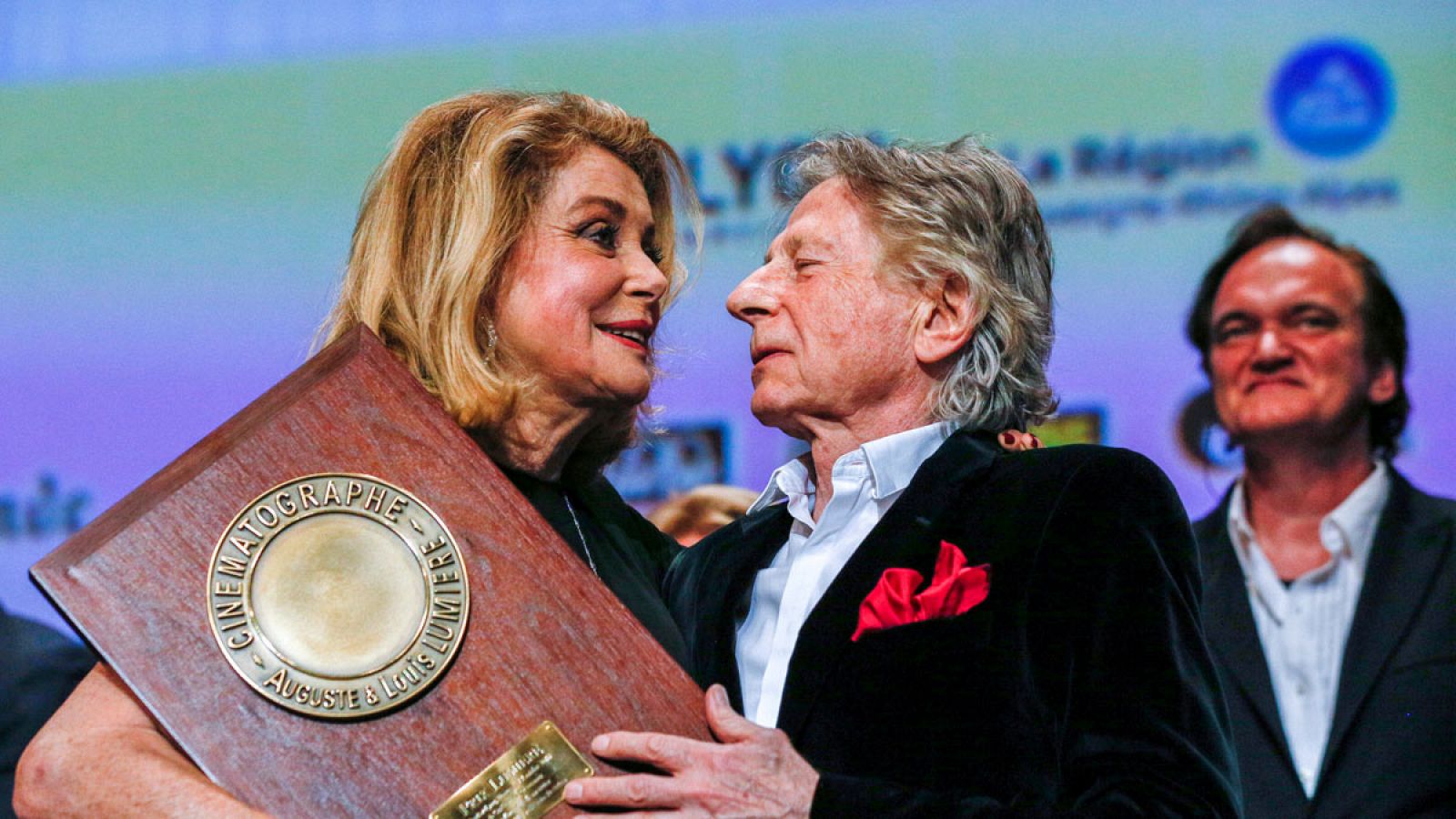 Deneuve recogiendo el premio de la mano del director Roman Polanski.