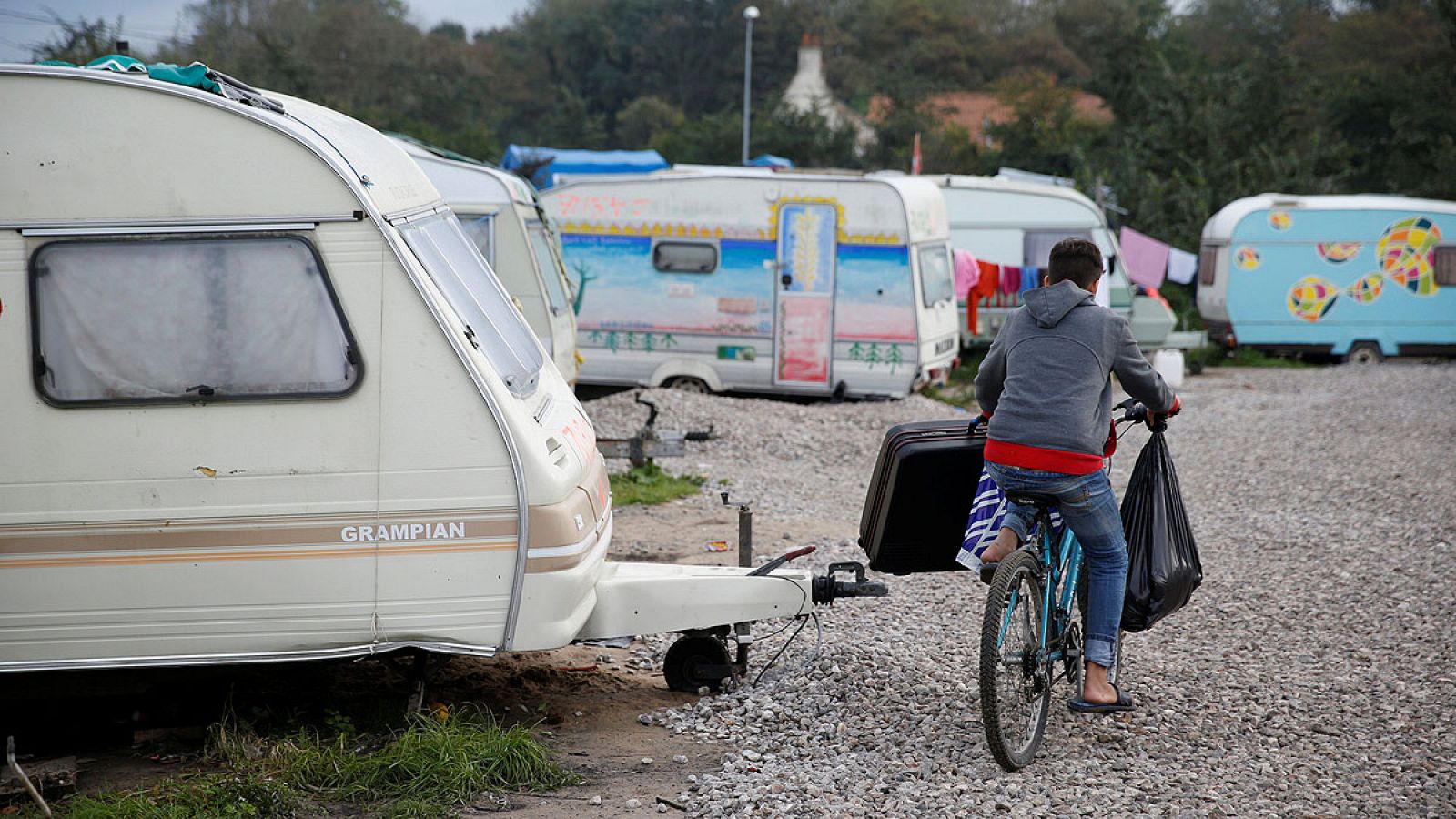 Un inmigrante afgano de 14 años recoge sus cosas del campo de Calais