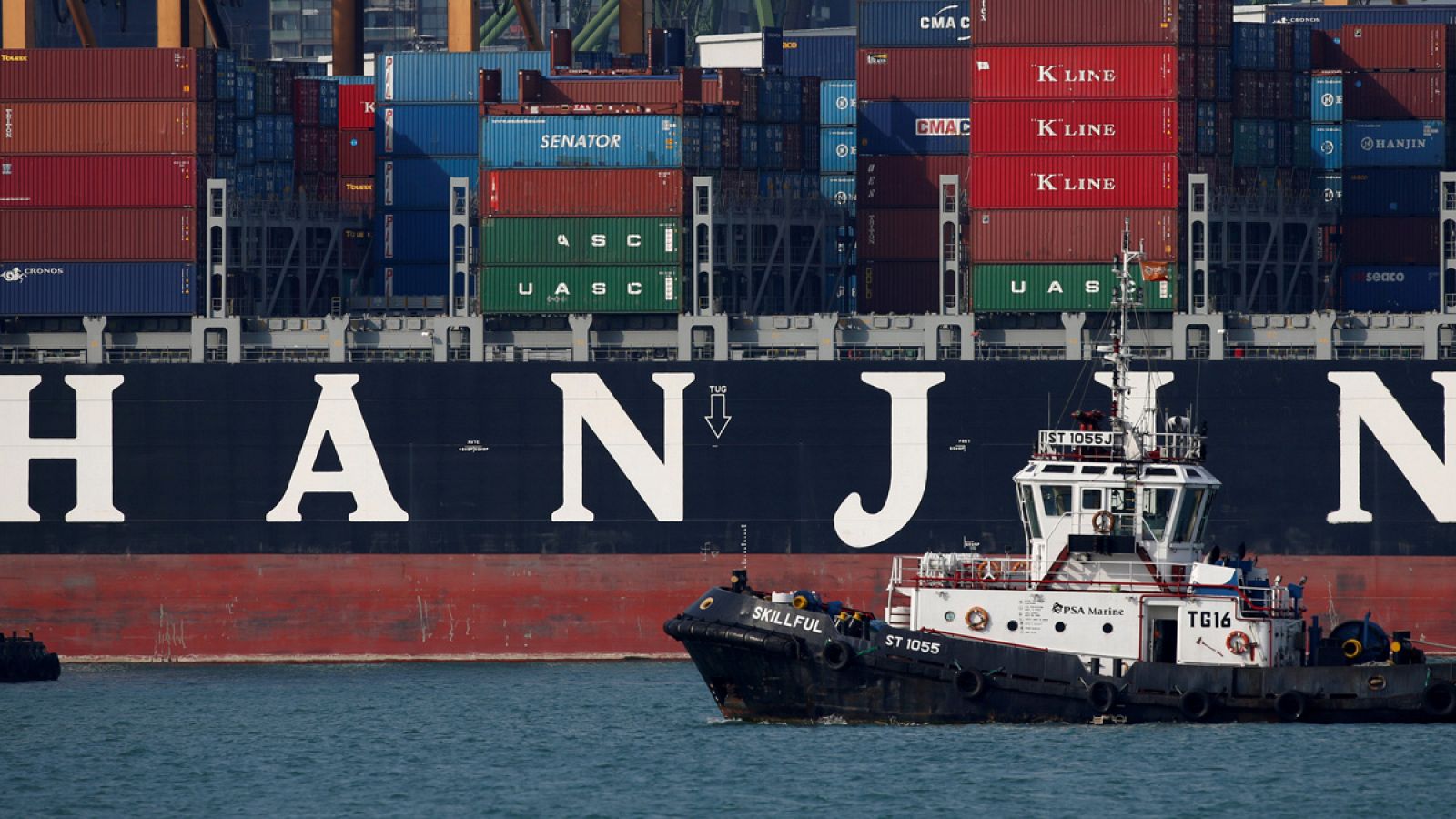 Un remolcador pasa junto un buque de Hanjin en el puerto de Singapur