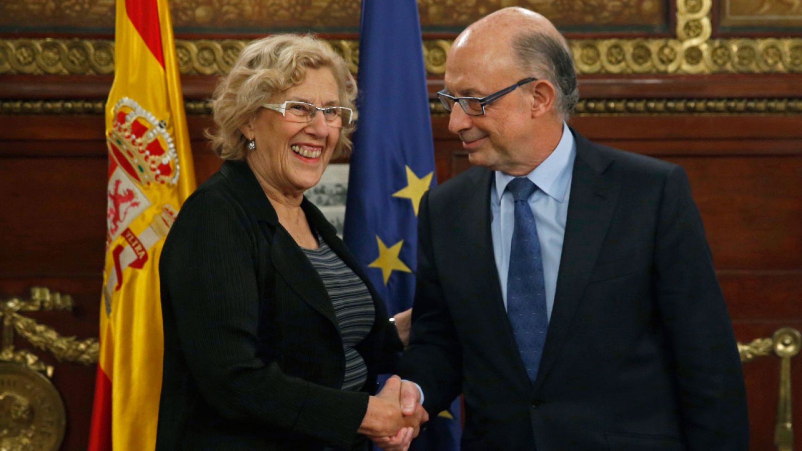 La alcaldesa de Madrid, Manuela Carmena (i), y el ministro de Hacienda, Cristóbal Montoro, este lunes