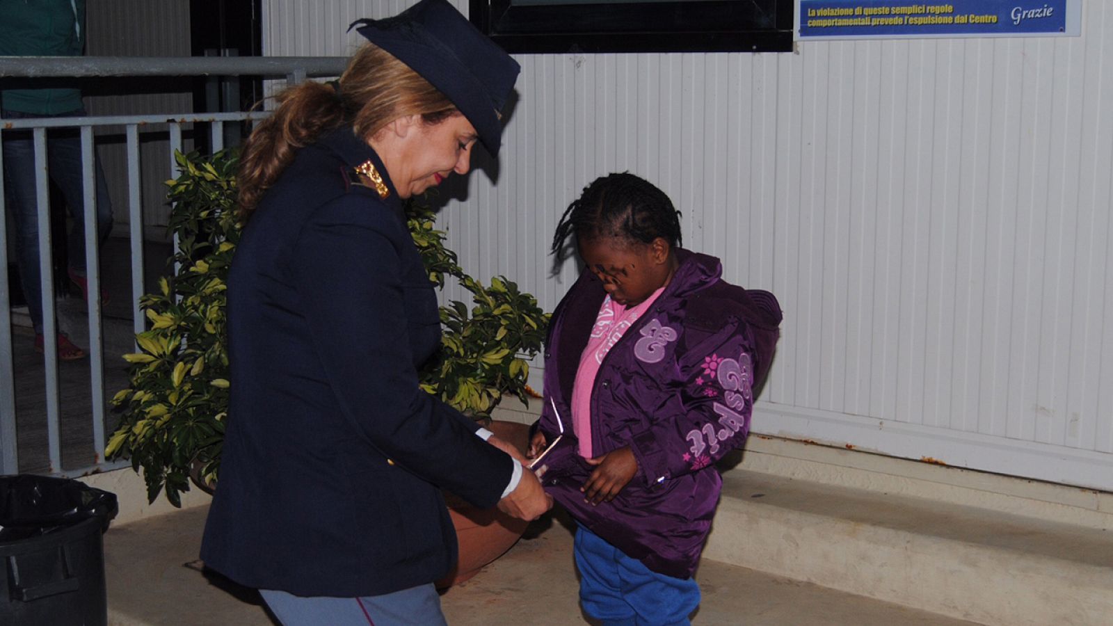 La niña marfileña Oumoh es atendida por la agente de policía María Volpe en Lampedusa