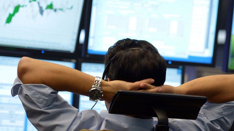 Un broker observa varios monitores en la bolsa