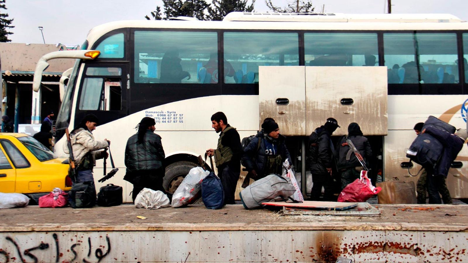 Un grupo de milicianos rebeldes, antes de ser evacuados de Alepo