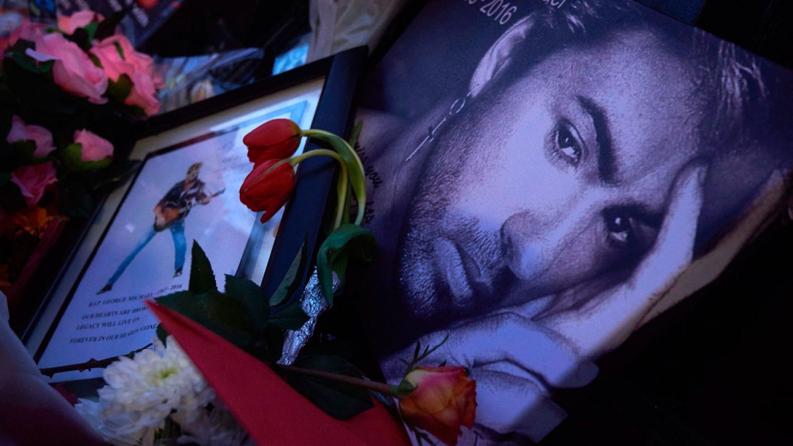 Mensajes, velas y flores junto a un retrato del difunto George Michael, en las puertas de la que era su casa en el norte de Londres