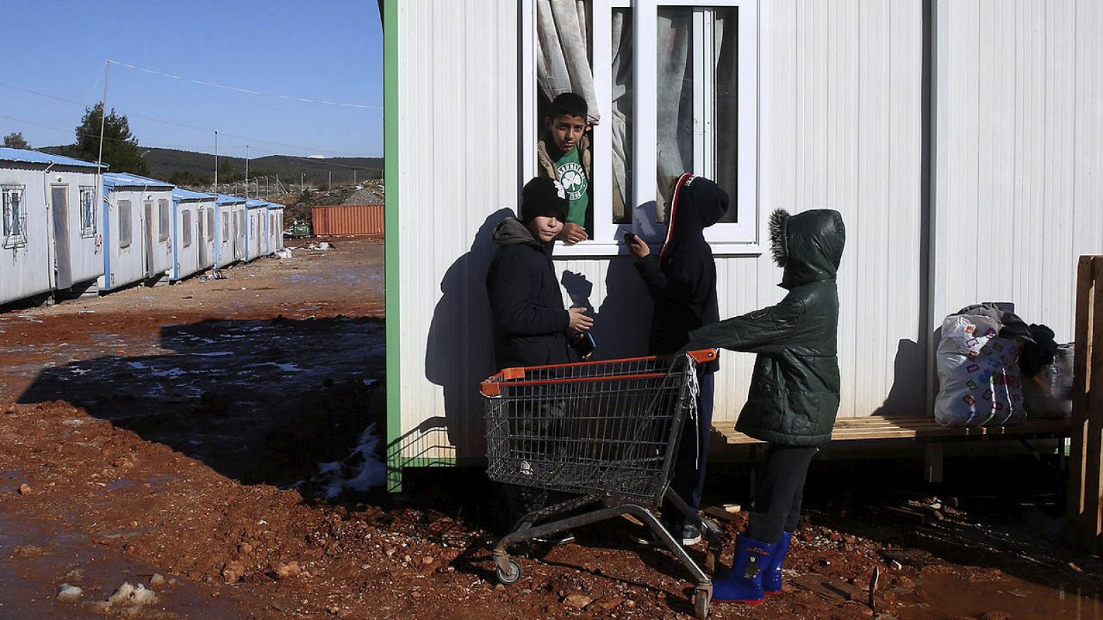 Niños refugiados hablan en el barracón donde viven en el campamento de refugiados de Malakasa, a 60 kilómetros de Atenas, Grecia