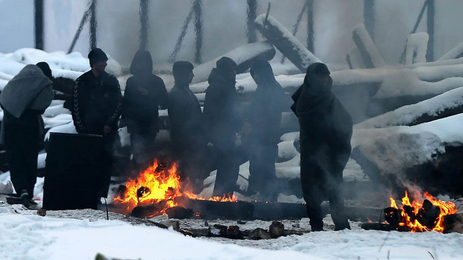 Refugiados se protegen del frío con una hoguera en un almacén aduanero abandonado en Belgrado, Serbia