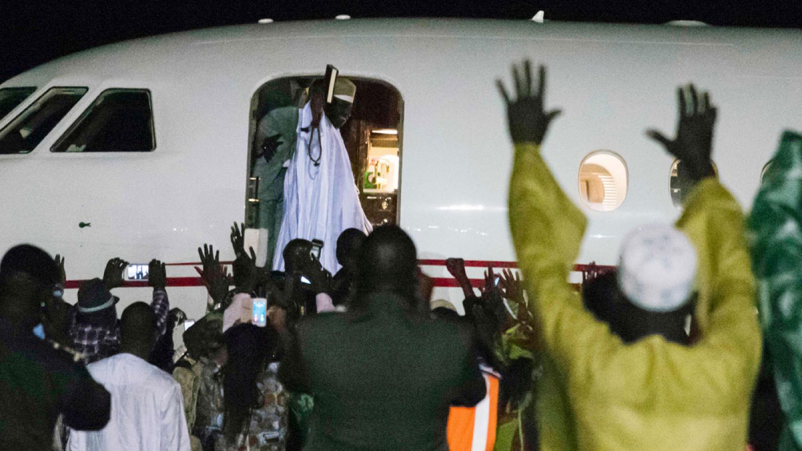 Yahya Jammeh saluda a la gente al subirse al avión que le llevará al exilio en Guinea Conakry.