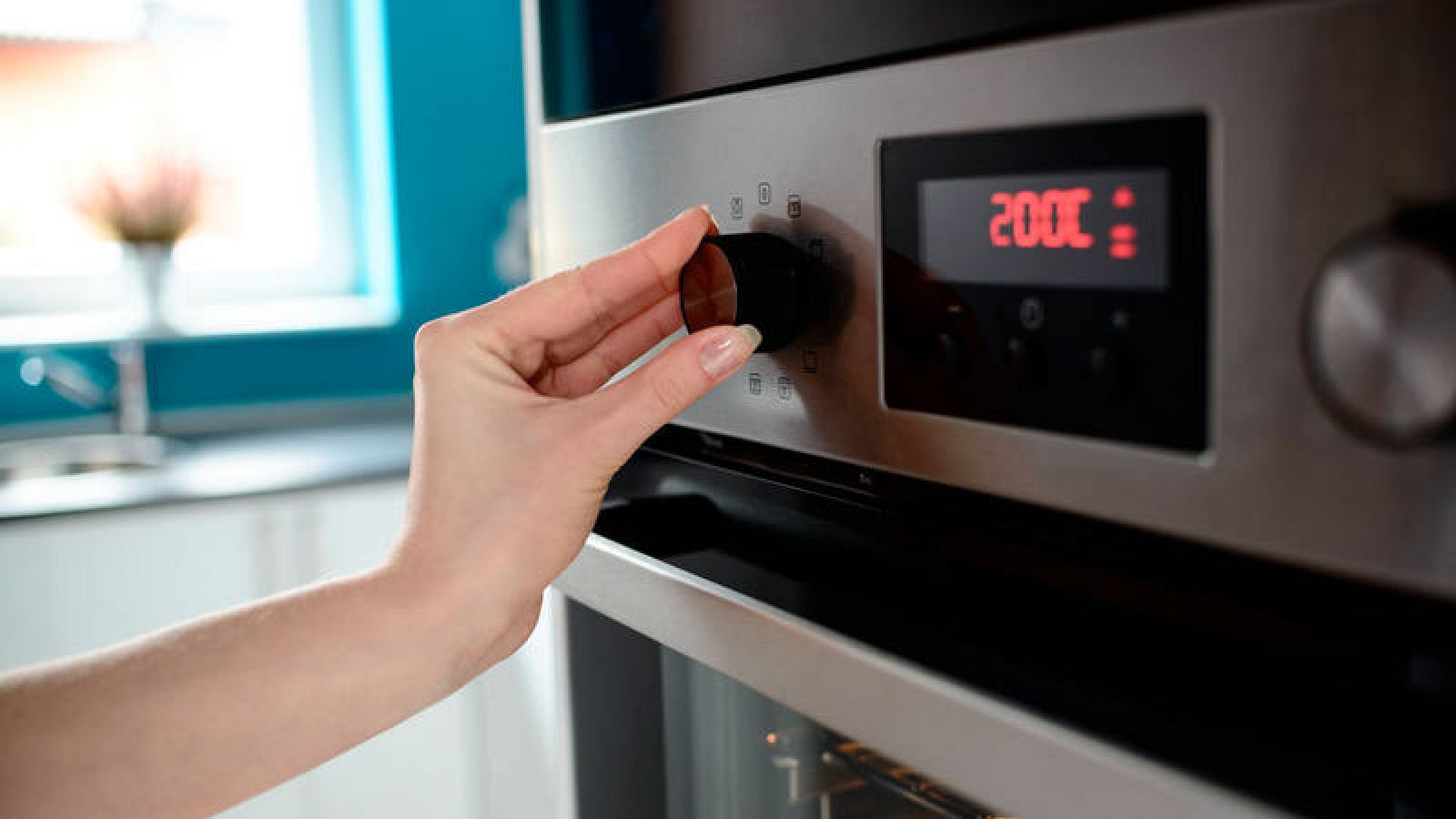 Imagen de archivo de una persona poniendo en su casa el horno eléctrico