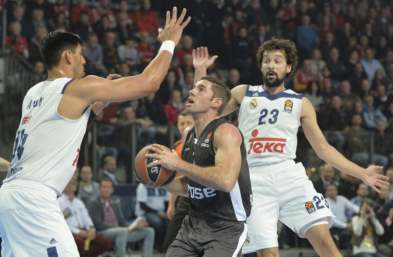 Causeur del Brose lucha por el balón contra Ayón y Llull.