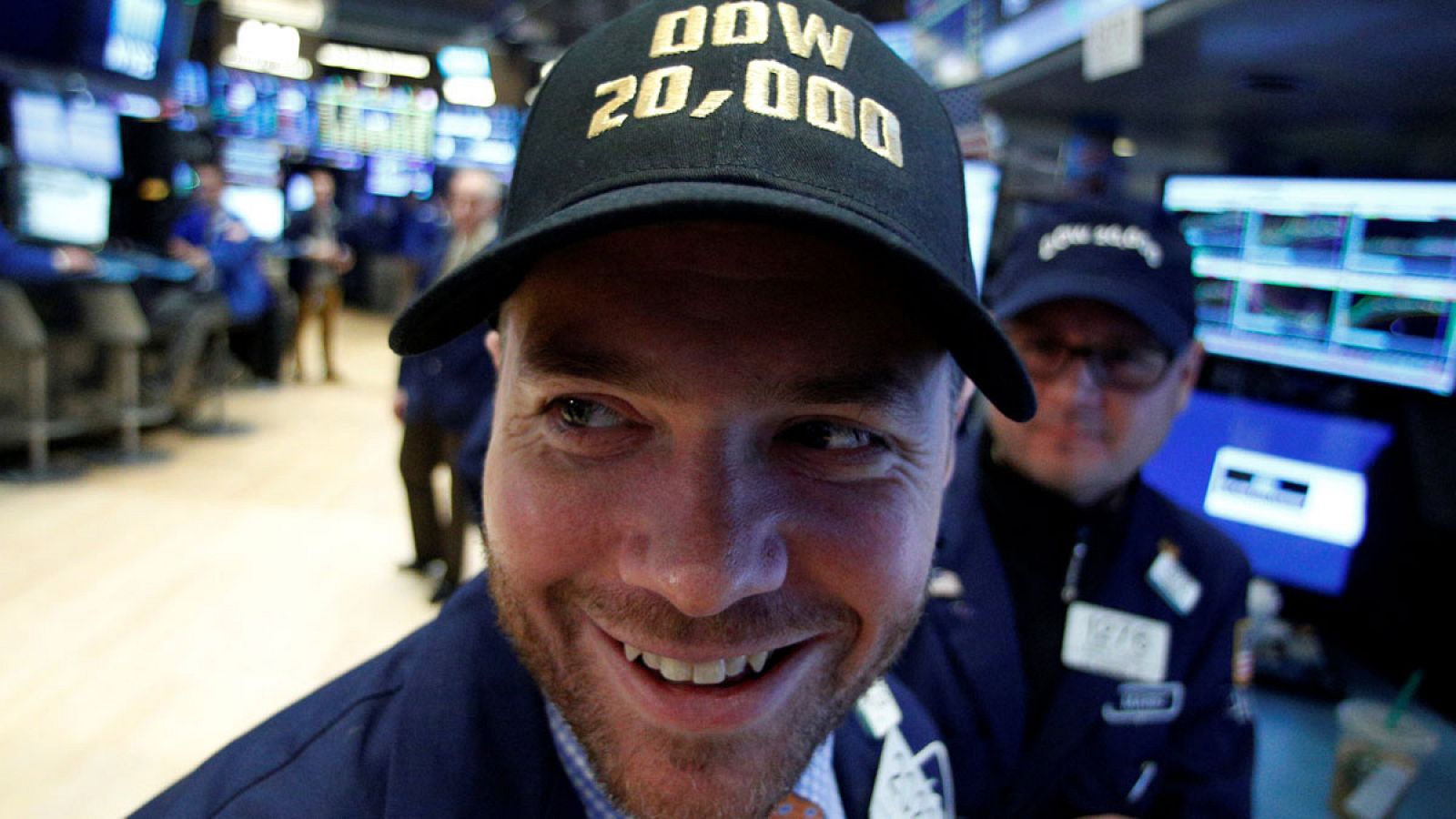 Los trabajadores de la bolsa de Nueva York lucen gorras con la cifra récord de 20.000 puntos alcanzada por el Dow Jones.