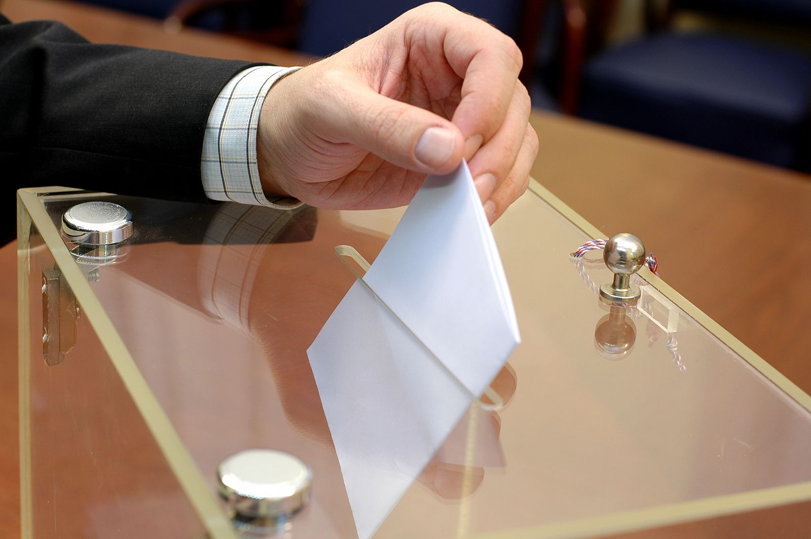 Un hombre deposita un voto en una urna electoral